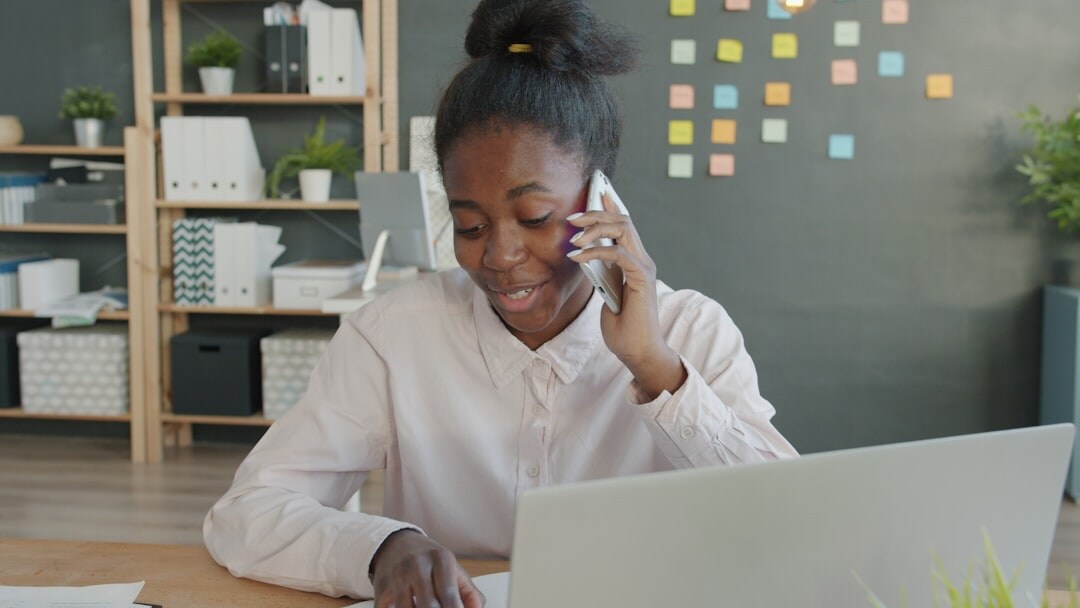 Indonesian customer service team member answering calls at a desk